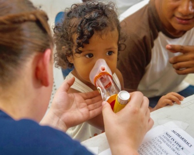 150428-N-NK134-129 PUERTO BARRIOS, Guatemala (April 28, 2015) – Hospital Corpsman 3rd Class Alysann Barnes, assigned to Naval Hospital Camp Lejeune Jacksonville, N.C., teaches a child how to use an inhaler at a medical site set up at Casa Social del Maestro Prof. Leopoldo in Puerto Barrios during Continuing Promise 2015. Continuing Promise is a U.S. Southern Command-sponsored and U.S. Naval Forces Southern Command/U.S. 4th Fleet-conducted deployment to conduct civil-military operations including humanitarian-civil assistance, subject matter expert exchanges, medical, dental, veterinary and engineering support and disaster response to partner nations and to show U.S. support and commitment to Central and South America and the Caribbean. (U.S. Navy photo by Mass Communication Specialist 2nd Class Derek Paumen/Released)